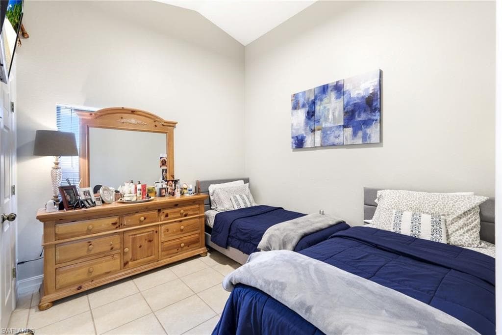 Bedroom featuring lofted ceiling and light tile patterned flooring