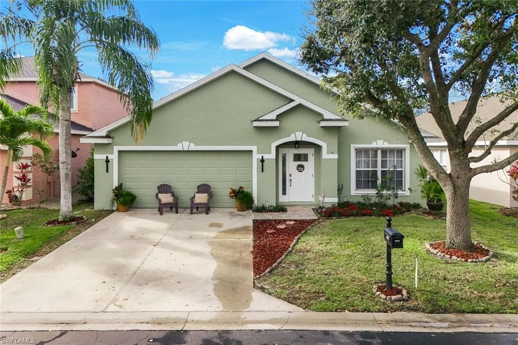 Single story home featuring driveway, a front lawn, an attached garage, and stucco siding
