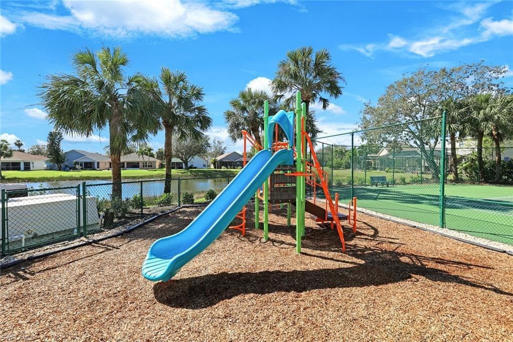 Community playground featuring a water view and fence