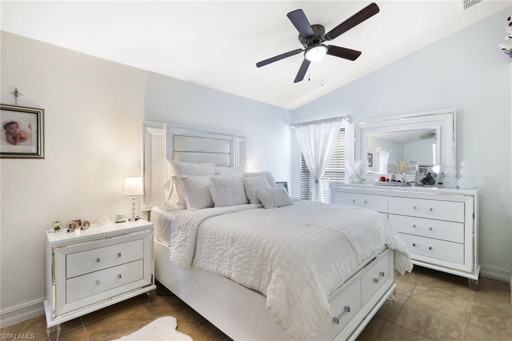 Bedroom featuring visible vents, vaulted ceiling, baseboards, and ceiling fan