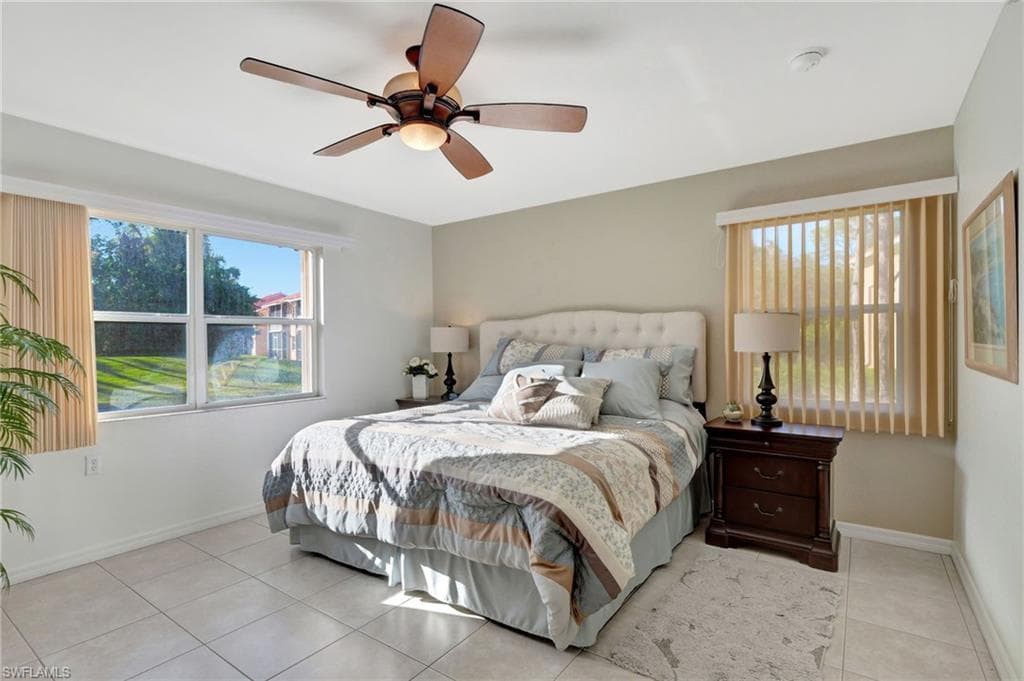 Bedroom with light tile patterned floors, ceiling fan, and baseboards