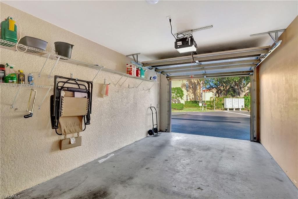 Garage with a textured wall and a garage door opener