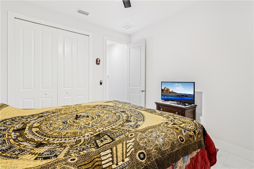 Bedroom featuring ceiling fan, a closet, visible vents, and baseboards