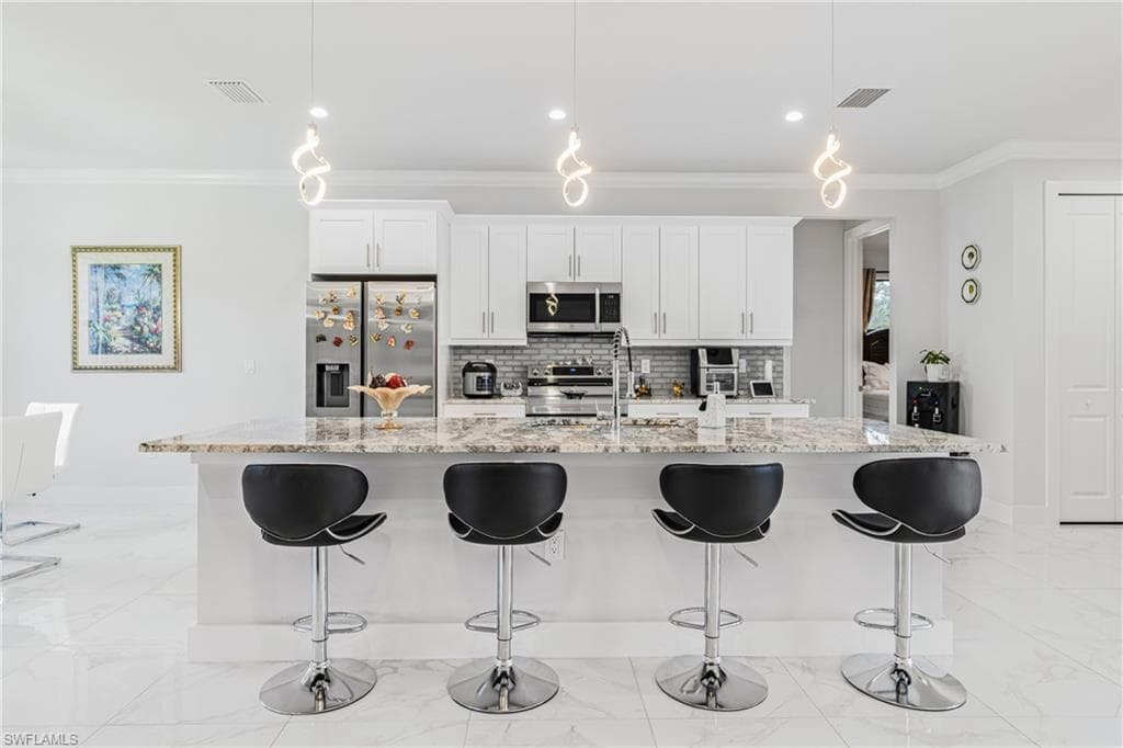 Kitchen with a breakfast bar, marble finish floor, and stainless steel appliances