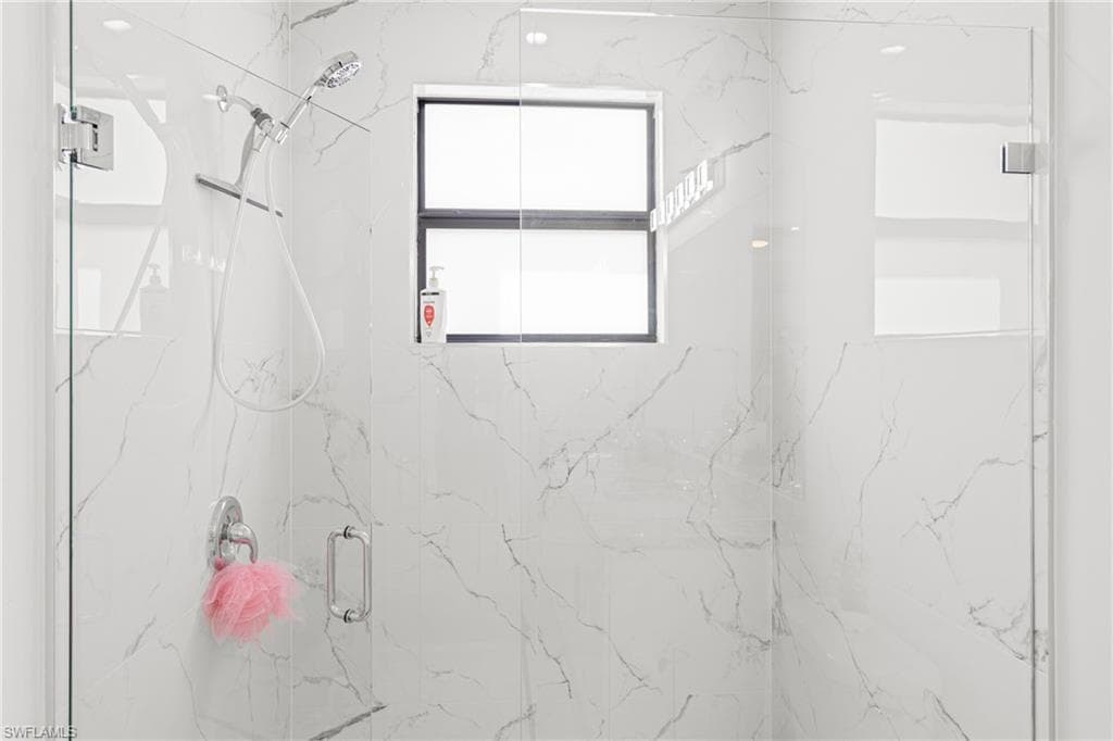 Full bath featuring a marble finish shower