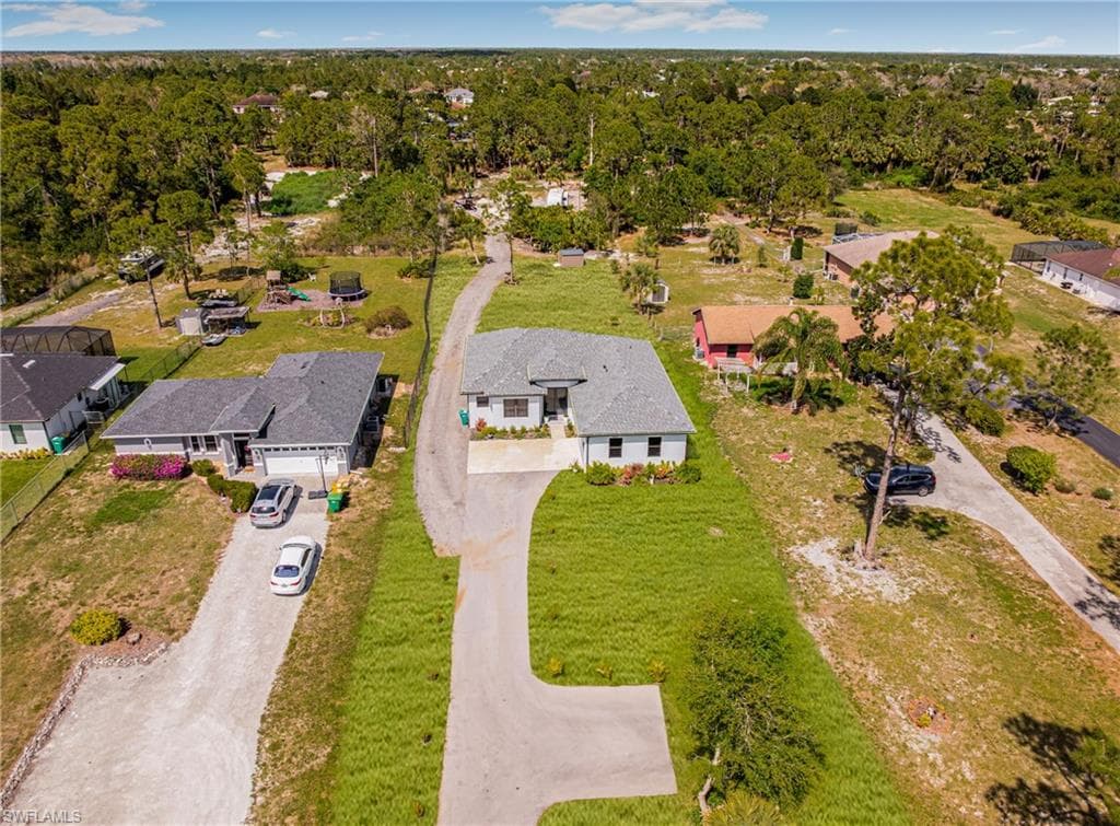 Drone / aerial view featuring a residential view and a wooded view