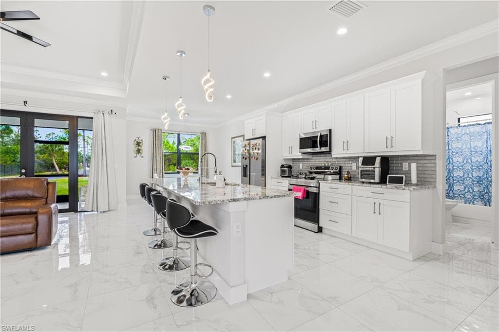 Kitchen featuring ornamental molding, marble finish floor, appliances with stainless steel finishes, and visible vents