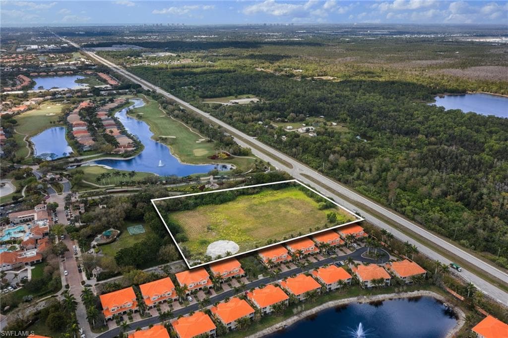 Aerial view featuring a water view and a view of trees