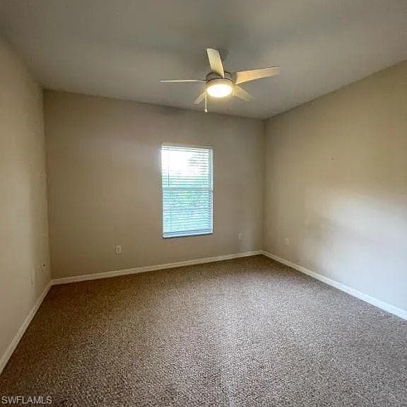 Empty room with a ceiling fan and baseboards