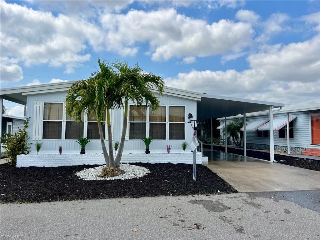 Manufactured / mobile home featuring driveway and an attached carport