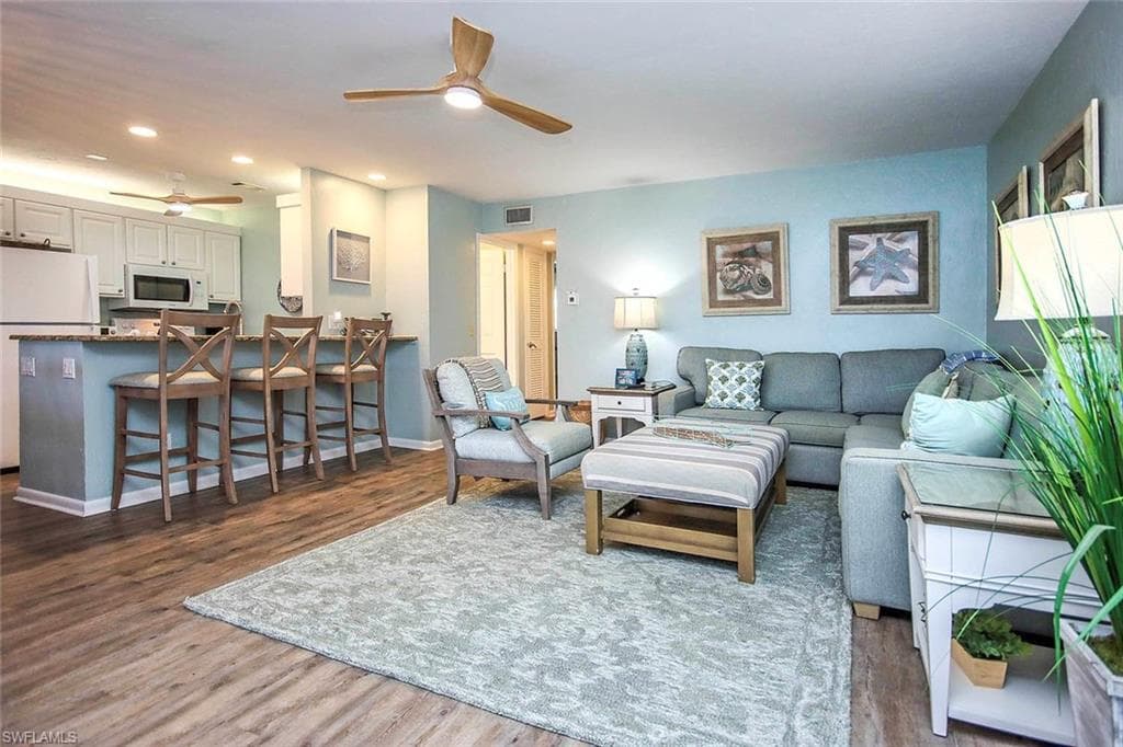 Living room with visible vents, a ceiling fan, wood finished floors, recessed lighting, and baseboards