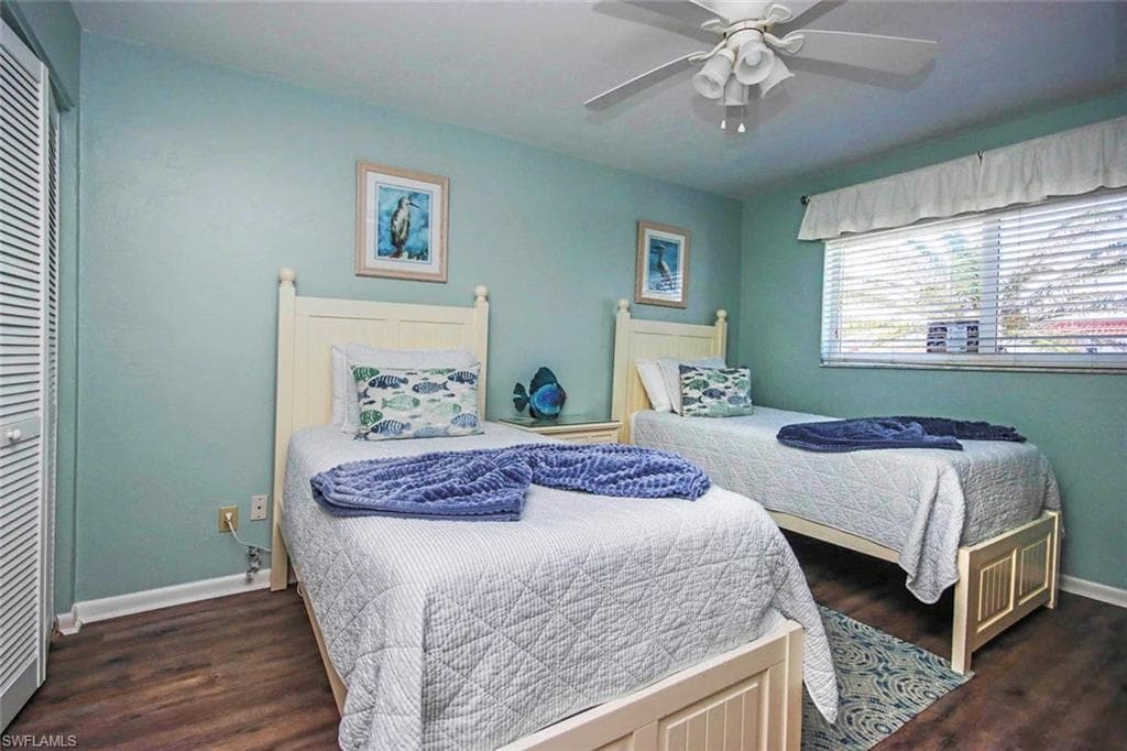 Bedroom featuring a ceiling fan, wood finished floors, and baseboards