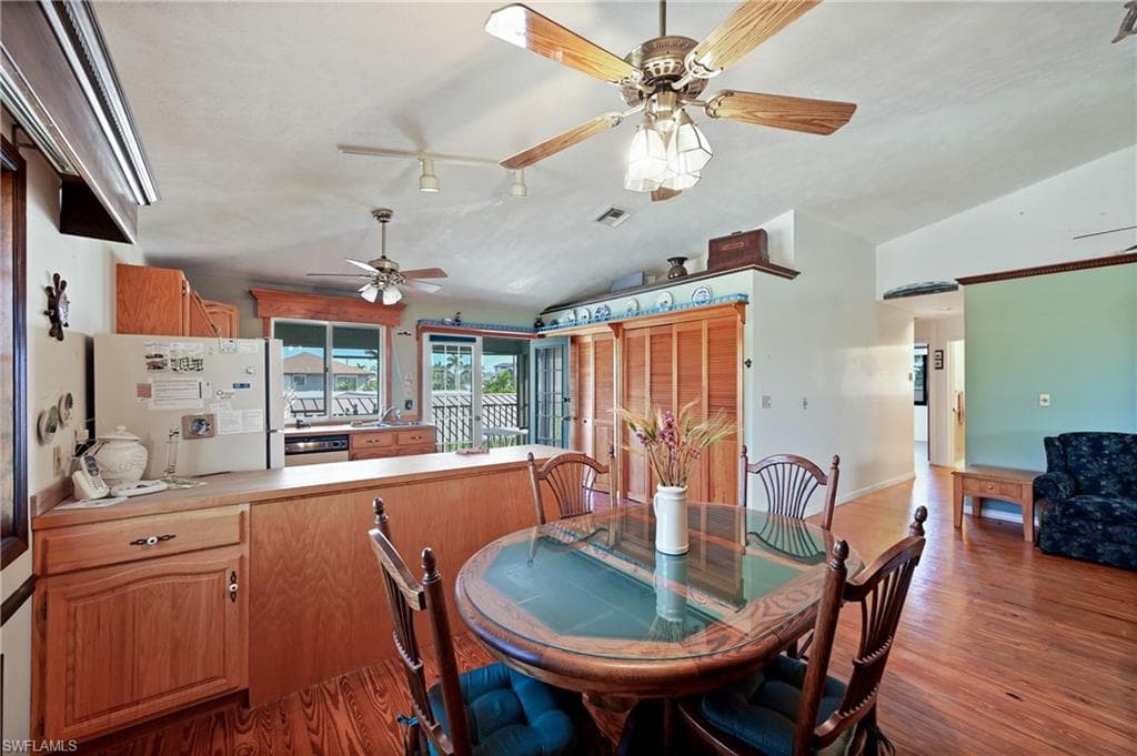 Dining space featuring vaulted ceiling, wood finished floors, and ceiling fan