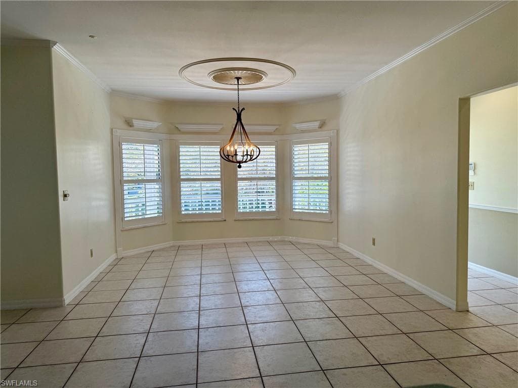 Empty room featuring a wealth of natural light, ornamental molding, and light tile patterned flooring