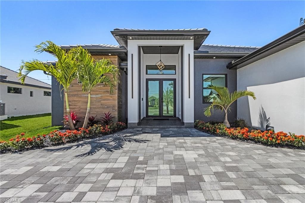 Entrance to property with central air condition unit, french doors, and stucco siding