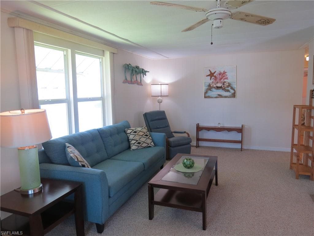 Living area featuring carpet flooring and ceiling fan