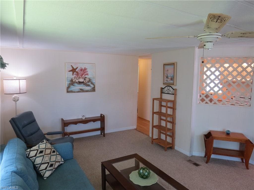 Living room featuring carpet floors and ceiling fan