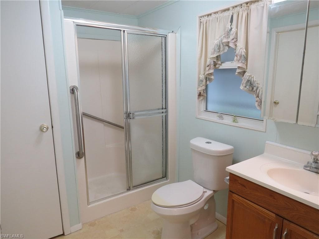 Full bath with a shower stall and vanity