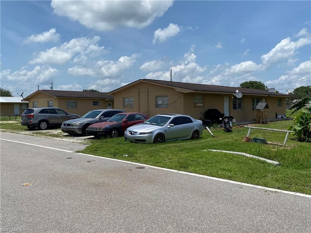 Single story home featuring a front yard and uncovered parking