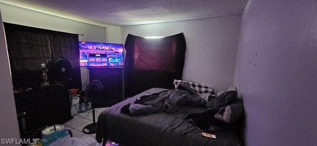 Bedroom with a textured ceiling and tile patterned floors