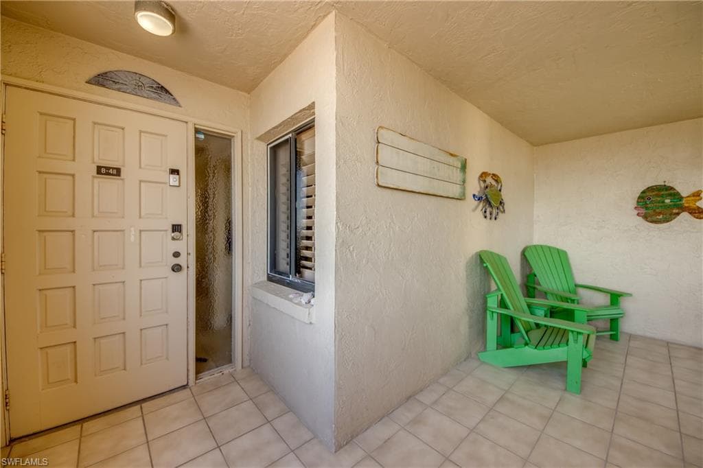 Screened in front porch looking at front door to unit