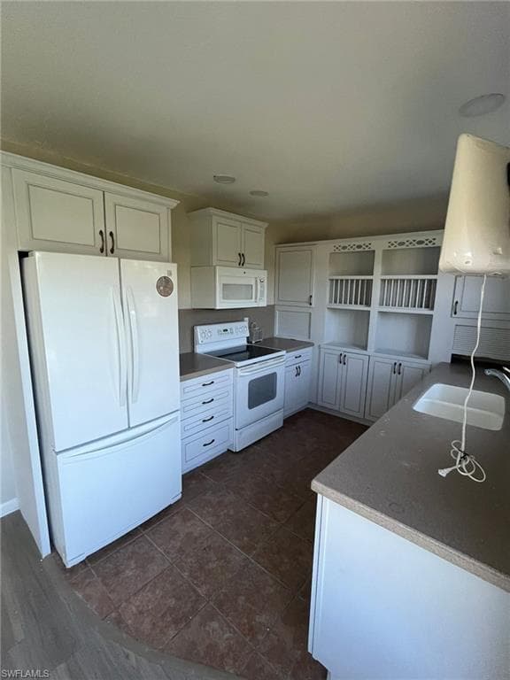 Kitchen with white cabinets, a sink, open shelves, and white appliances
