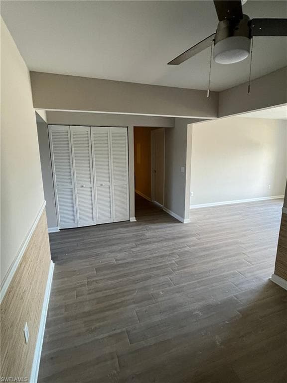 Unfurnished bedroom featuring baseboards, ceiling fan, and wood finished floors