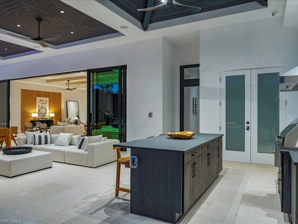 Kitchen featuring a kitchen breakfast bar, recessed lighting, a raised ceiling, a kitchen island, and a ceiling fan