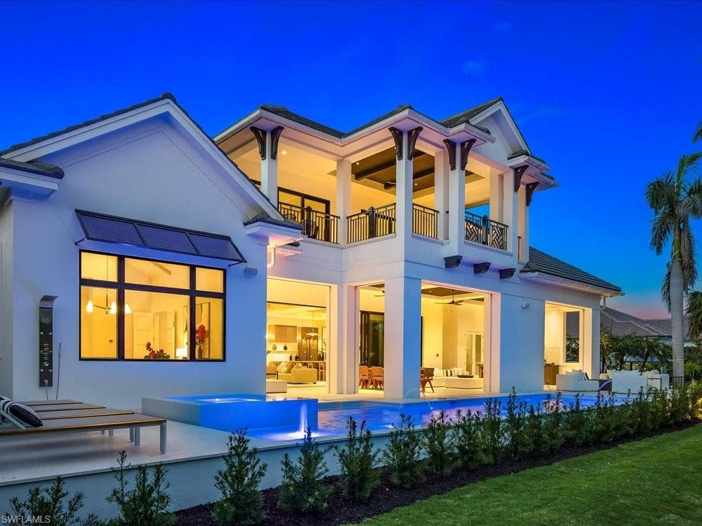 Back of house featuring a balcony, stucco siding, an outdoor pool, and a patio area