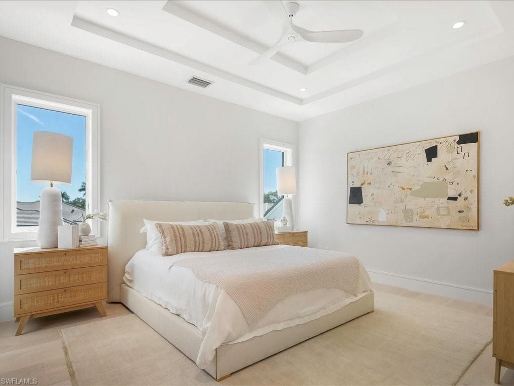 Bedroom with a ceiling fan, a raised ceiling, baseboards, visible vents, and recessed lighting