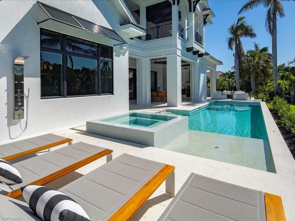 View of swimming pool featuring outdoor lounge area, a pool with connected hot tub, and a patio area
