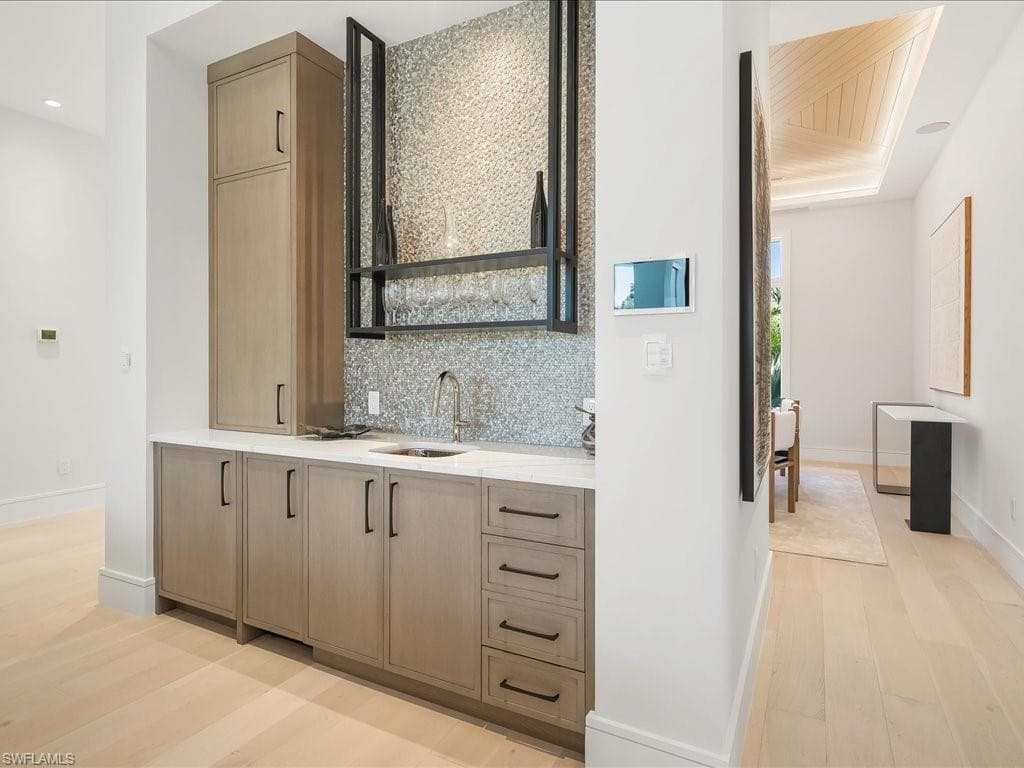 Bathroom featuring vanity, recessed lighting, baseboards, decorative backsplash, and wood finished floors