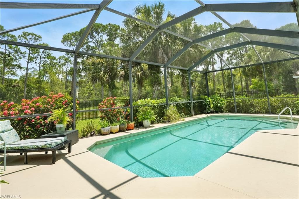 Stunning screened-in pool area with lush preserve views, offering ultimate privacy and a true Florida lifestyle. Covered patio with ceiling fans creates a perfect space for outdoor dining or relaxing in the shade. The sparkling pool is surrounded by tropical landscaping and ample deck space for lounging or entertaining. Ideal for year-round enjoyment, this backyard retreat blends comfort and nature—just minutes from Gulf beaches, shopping, and dining.