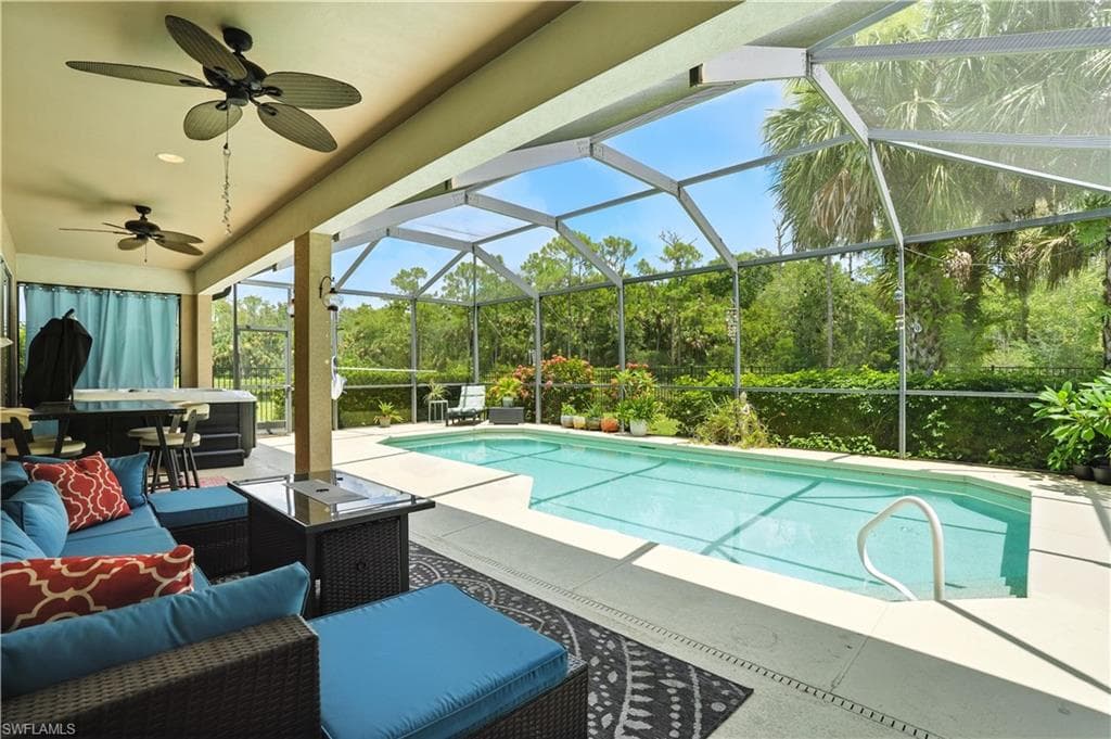 Stunning screened-in pool area with lush preserve views, offering ultimate privacy and a true Florida lifestyle. Covered patio with ceiling fans creates a perfect space for outdoor dining or relaxing in the shade. The sparkling pool is surrounded by tropical landscaping and ample deck space for lounging or entertaining. Ideal for year-round enjoyment, this backyard retreat blends comfort and nature—just minutes from Gulf beaches, shopping, and dining.