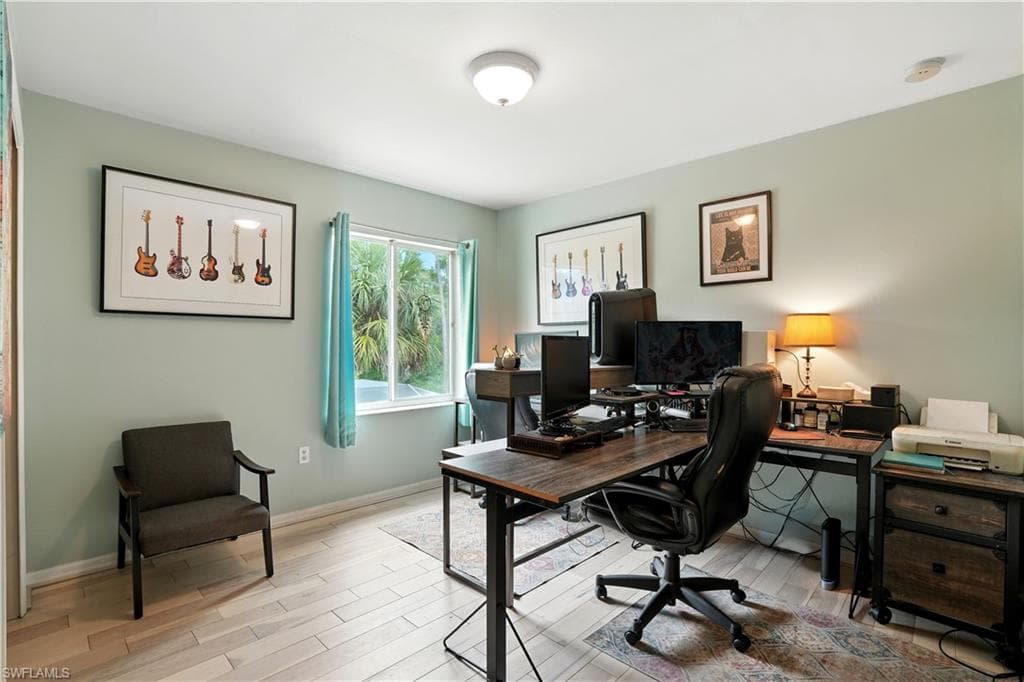 Versatile bedroom or home office with sleek dark gray walls, wood-look flooring, and a large window bringing in natural light. Ample space for desks, shelving, or creative setups makes it perfect for work-from-home, gaming, or hobbies. LED accent lighting adds a modern touch, while the neutral palette allows for easy personalization.