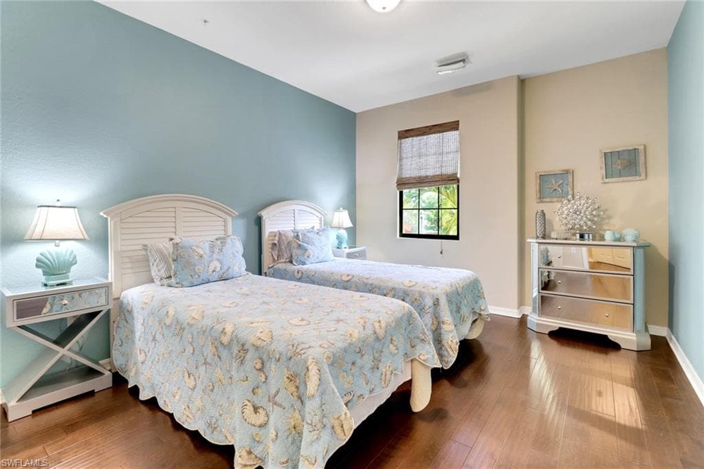 Bedroom featuring wood-type flooring and baseboards