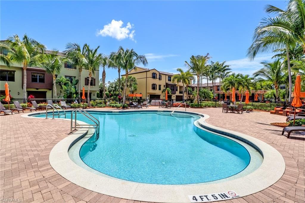 Pool with a patio area and fence