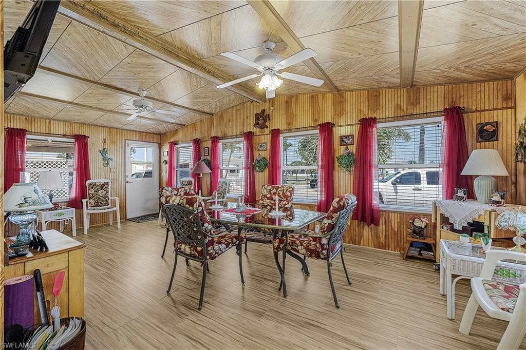 Dining space with a healthy amount of sunlight, wooden walls, and a ceiling fan