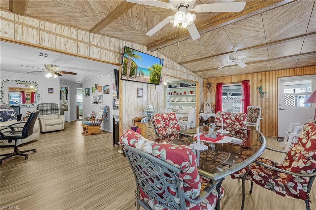 Dining room with wood walls, ceiling fan, wooden ceiling, and wood finished floors