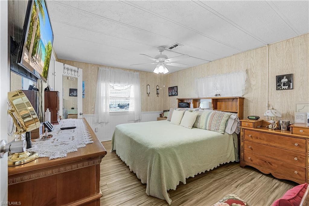 Bedroom featuring wood finished floors, ceiling fan, and visible vents