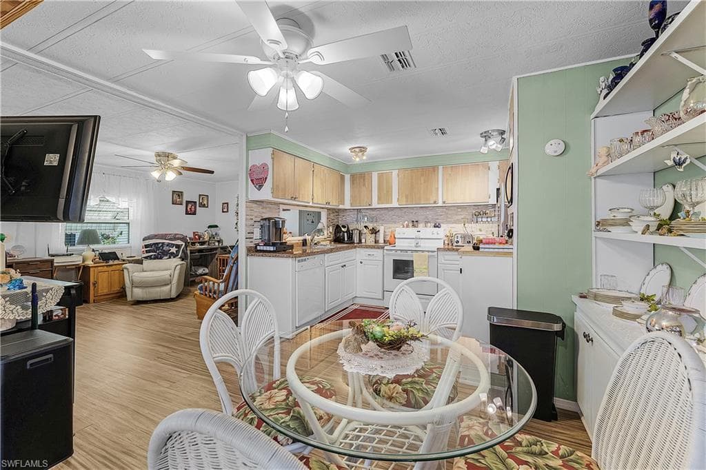 Dining space featuring visible vents, a ceiling fan, and light wood finished floors
