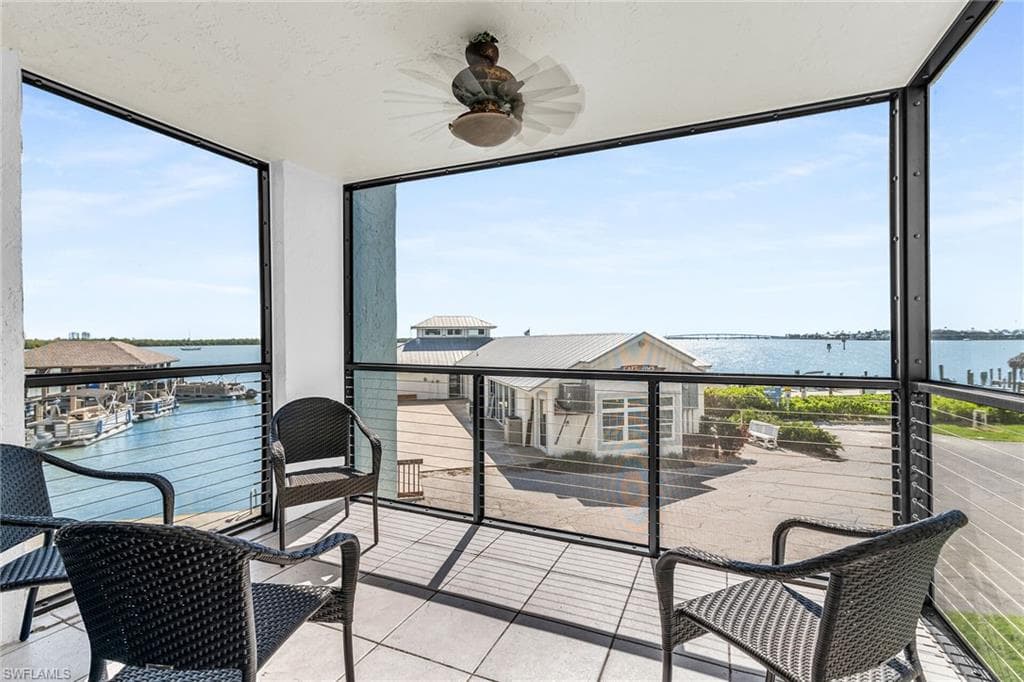 Sunroom / solarium with a water view and ceiling fan