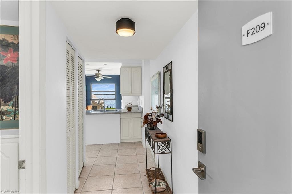 Hallway with a sink and light tile patterned flooring