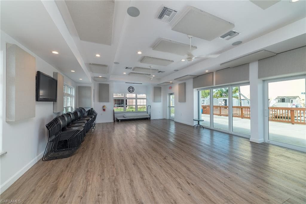 Living area featuring wood finished floors, visible vents, and a healthy amount of sunlight
