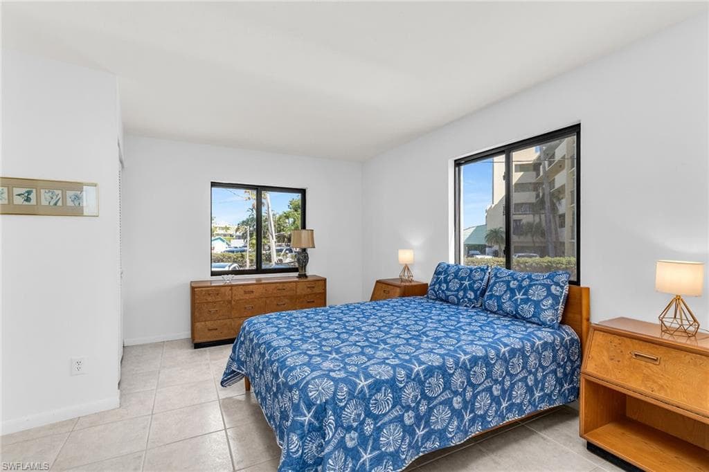 Bedroom with light tile patterned flooring and baseboards