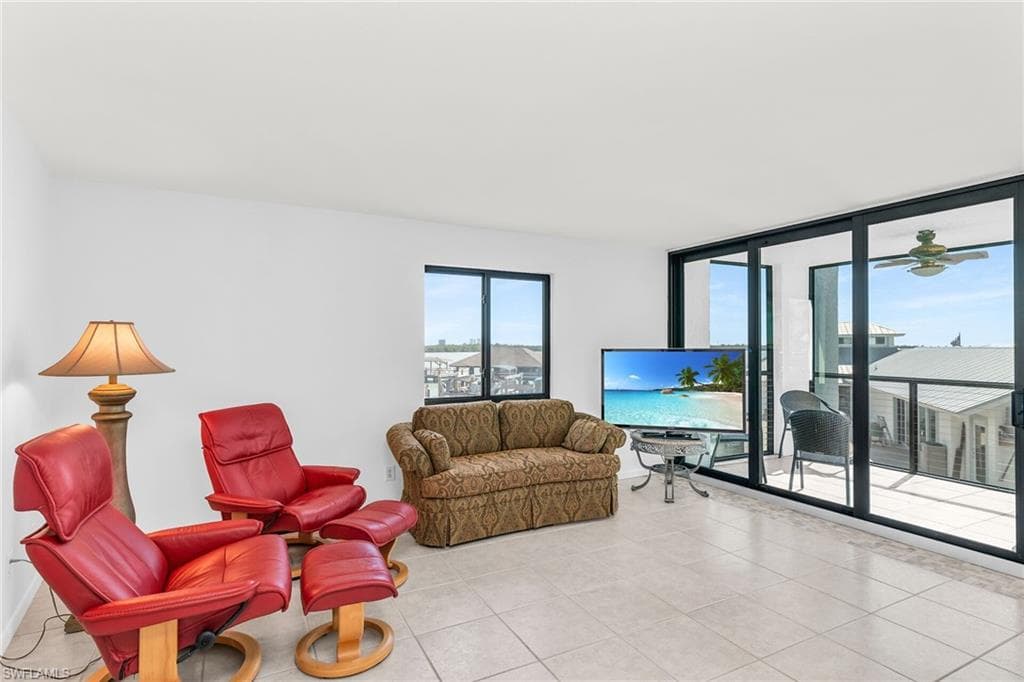 Living area featuring a wall of windows and light tile patterned flooring