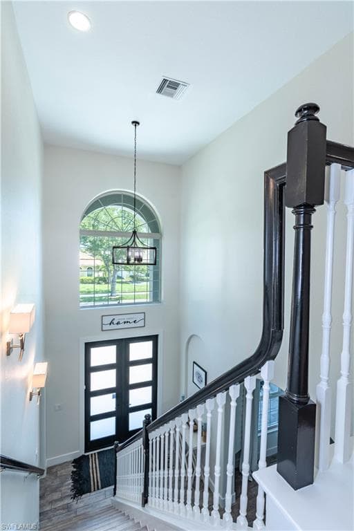 Foyer entrance with french doors, recessed lighting, and a modern chandelier