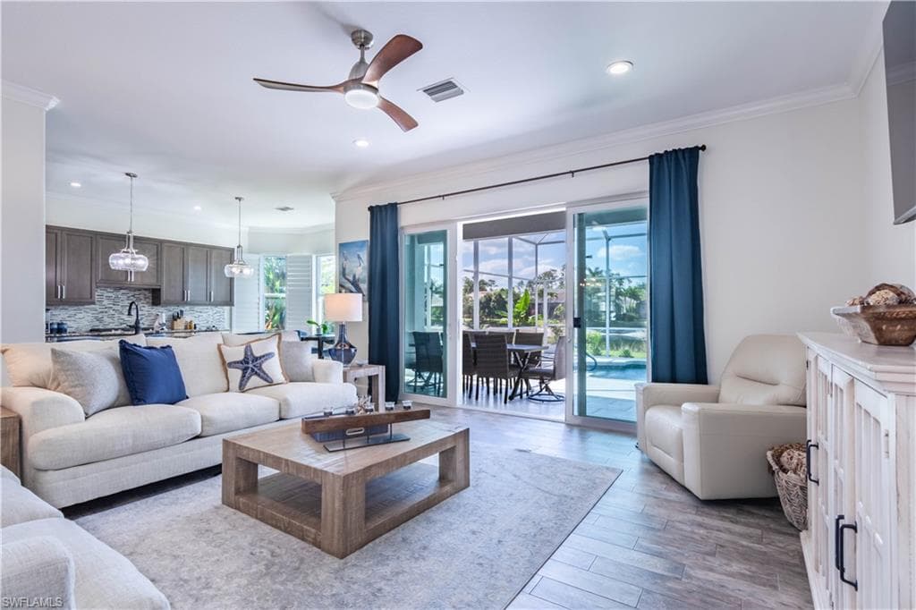 Living room featuring recessed lighting, crown molding, and ceiling fan