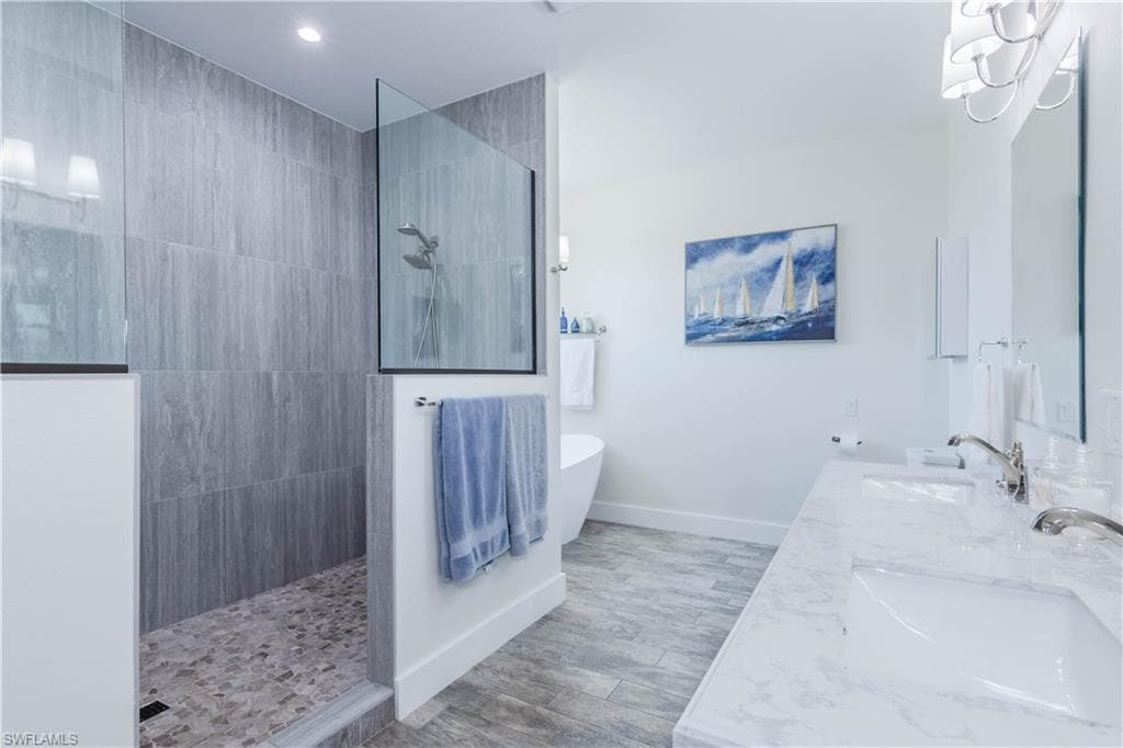 Primary bath featuring a extremely large walk in shower and a freestanding soaking tub