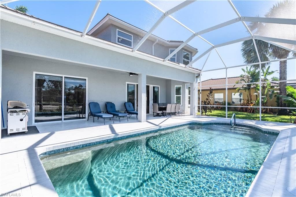 Outdoor pool featuring screen enclosure, grilling area, a patio, and ceiling fan